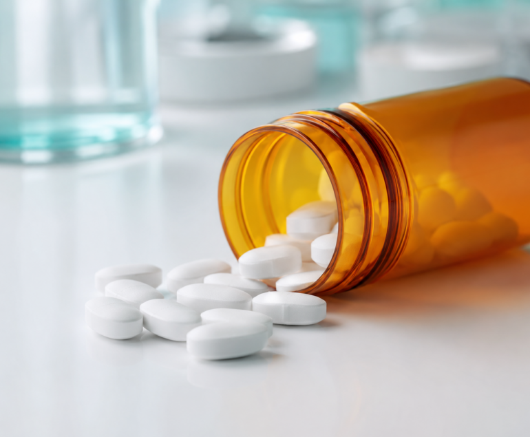 Pastillas de atorvastatina sobre superficie clínica blanca, representando el tratamiento con estatinas para el colesterol alto